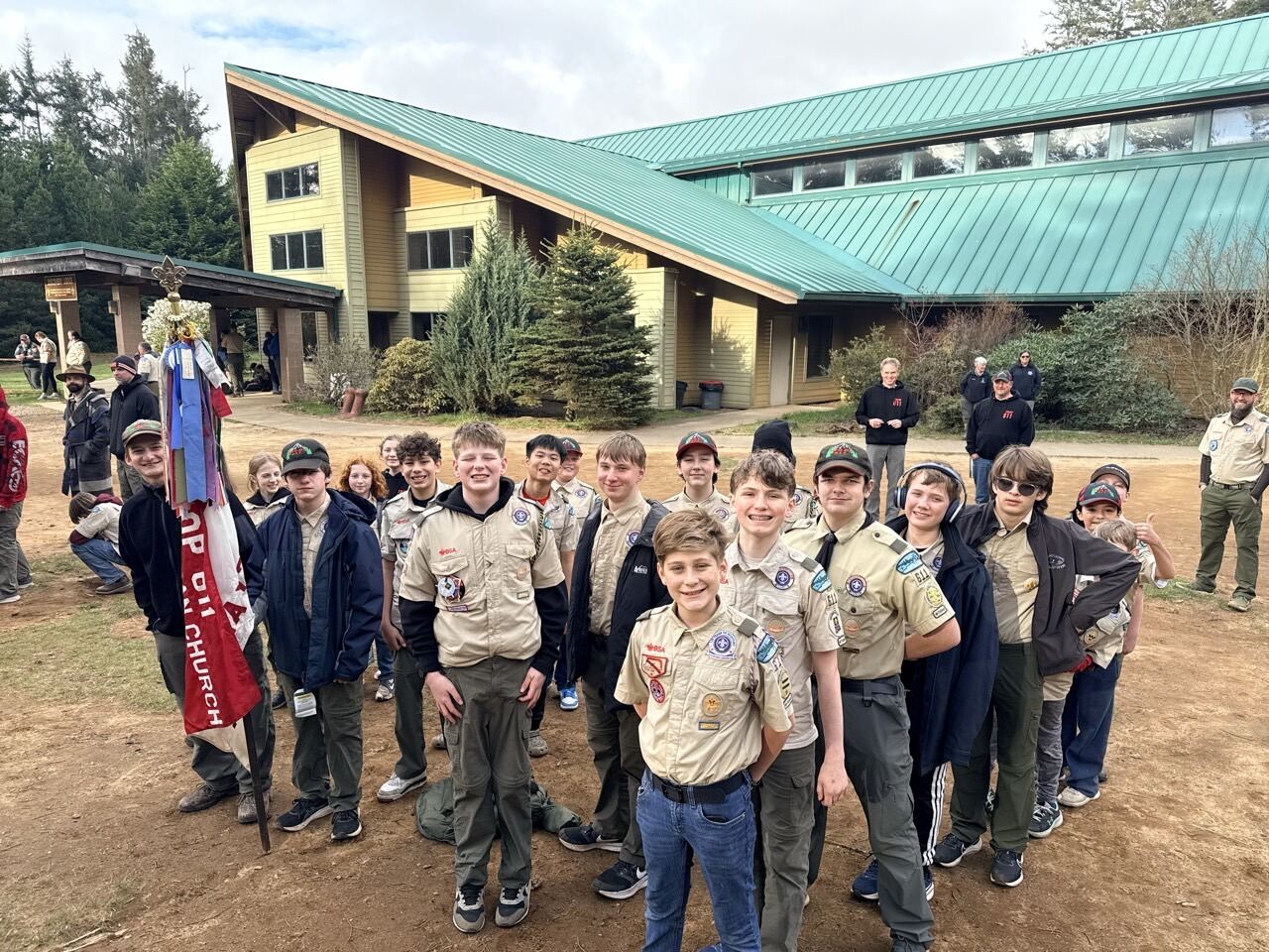 Scouts in uniform gathered outside the Camp Meriwether lodge